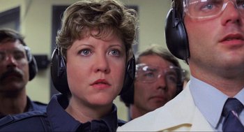 Movie still from “RoboCop” (1987), directed by Paul Verhoeven – A woman wearing ear muffs while looking into the distance; Close Up shot, Low angle