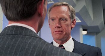 Movie still from “RoboCop” (1987), directed by Paul Verhoeven – A man in a suit looking at himself in the mirror; Close Up shot, Over the shoulder angle