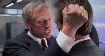 Movie still from “RoboCop” (1987), directed by Paul Verhoeven – A man in a suit and tie fighting with another man in a suit and tie; Close Up shot, Over the shoulder angle