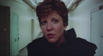 Movie still from “RoboCop” (1987), directed by Paul Verhoeven – A woman's face in front of a television screen; Close Up shot, Low angle