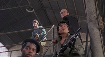 Movie still from “RoboCop” (1987), directed by Paul Verhoeven – A group of men standing next to each other holding guns; Medium shot, Low angle