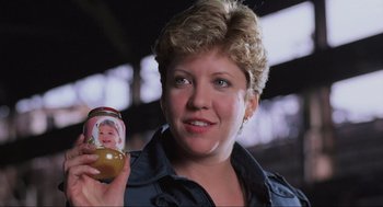 Movie still from “RoboCop” (1987), directed by Paul Verhoeven – A woman holding a jar with a picture of a child on it; Close Up shot, Low angle