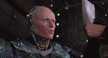 Movie still from “RoboCop” (1987), directed by Paul Verhoeven – A man's face in a robot suit; Close Up shot, Low angle