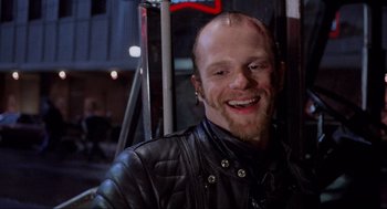 Movie still from “RoboCop” (1987), directed by Paul Verhoeven – A man in a leather jacket smiling for the camera; Close Up shot, Low angle