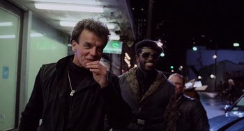 Movie still from “RoboCop” (1987), directed by Paul Verhoeven – A group of men standing next to each other on a street; Medium shot, Low angle