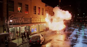 Movie still from “RoboCop” (1987), directed by Paul Verhoeven – A car that is on fire in the middle of the street; Extreme Wide shot, High angle