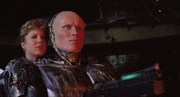 Movie still from “RoboCop” (1987), directed by Paul Verhoeven – A man in a robot suit is looking up; Close Up shot, Low angle
