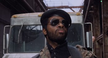Movie still from “RoboCop” (1987), directed by Paul Verhoeven – A person wearing a hat and sunglasses; Close Up shot, Low angle