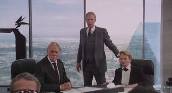 Movie still from “RoboCop” (1987), directed by Paul Verhoeven – A group of men in suits sitting at a table; Medium shot, Low angle