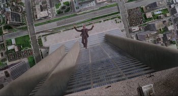 Movie still from “RoboCop” (1987), directed by Paul Verhoeven – A man standing on the side of a building with his arms outstretched; Extreme Wide shot, Overhead angle