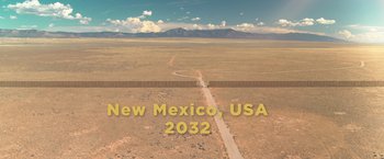 Movie still from “Robots” (2023), directed by Casper Christensen – An aerial view of a road in the middle of the desert; Extreme Wide shot, Overhead angle