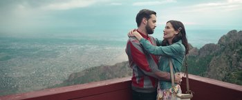 Movie still from “Robots” (2023), directed by Casper Christensen – A man and a woman hugging on a ledge; Medium shot, Low angle