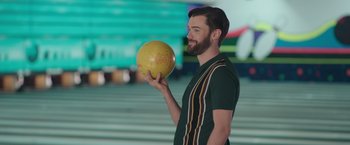 Movie still from “Robots” (2023), directed by Casper Christensen – A man holding a bowling ball in his hand; Medium shot, Low angle