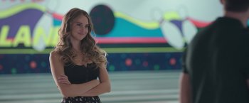 Movie still from “Robots” (2023), directed by Casper Christensen – A beautiful young lady standing in front of a painting; Close Up shot, Low angle