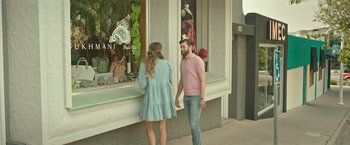 Movie still from “Robots” (2023), directed by Casper Christensen – A man and a woman standing in front of a store window; Wide shot, Over the shoulder angle
