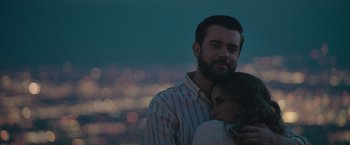 Movie still from “Robots” (2023), directed by Casper Christensen – A man and a woman hugging in front of a city skyline; Close Up shot, Over the shoulder angle