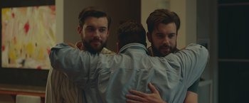 Movie still from “Robots” (2023), directed by Casper Christensen – Two men hugging each other in front of a mirror; Medium shot, Over the shoulder angle