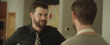 Movie still from “Robots” (2023), directed by Casper Christensen – A man wearing a tie talking to another man in front of a mirror; Close Up shot, Over the shoulder angle