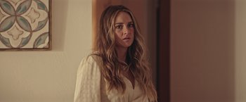 Movie still from “Robots” (2023), directed by Casper Christensen – A woman in a white shirt is standing in a room; Close Up shot, Over the shoulder angle