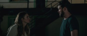 Movie still from “Robots” (2023), directed by Casper Christensen – A man and a woman standing next to each other in front of a staircase; Close Up shot, Over the shoulder angle