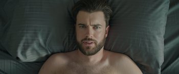 Movie still from “Robots” (2023), directed by Casper Christensen – A person laying in a bed; Close Up shot, Overhead angle