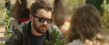 Movie still from “Robots” (2023), directed by Casper Christensen – A person wearing sunglasses and a leather jacket; Close Up shot, Over the shoulder angle