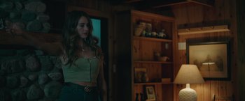 Movie still from “Robots” (2023), directed by Casper Christensen – A woman standing in front of a book shelf; Medium shot, Over the shoulder angle