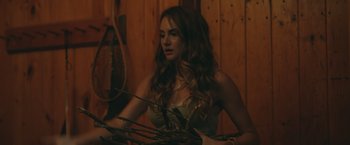 Movie still from “Robots” (2023), directed by Casper Christensen – A beautiful young woman holding a bunch of sticks; Medium shot, Over the shoulder angle