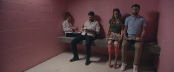 Movie still from “Robots” (2023), directed by Casper Christensen – A man and a woman sitting next to each other; Wide shot, High angle