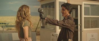 Movie still from “Robots” (2023), directed by Casper Christensen – A man holding a hair dryer in front of a woman; Medium shot, Over the shoulder angle