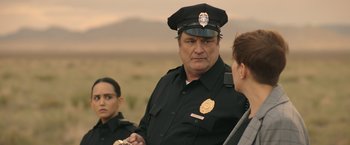 Movie still from “Robots” (2023), directed by Casper Christensen – A police officer talking to two other people; Close Up shot, Over the shoulder angle