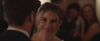 Movie still from “Robots” (2023), directed by Casper Christensen – A person smiling at a party; Close Up shot, Over the shoulder angle