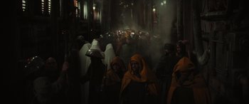 Movie still from “Rogue One: A Star Wars Story” (2016), directed by Gareth Edwards – A group of people standing around in a dark room; Wide shot, High angle