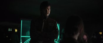 Movie still from “Rogue One: A Star Wars Story” (2016), directed by Gareth Edwards – A man with his arms crossed standing in a dark room; Close Up shot, Over the shoulder angle