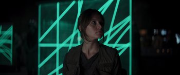 Movie still from “Rogue One: A Star Wars Story” (2016), directed by Gareth Edwards – A woman standing in front of a wall with green lights; Close Up shot, Low angle