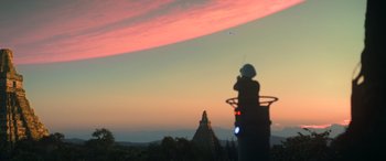 Movie still from “Rogue One: A Star Wars Story” (2016), directed by Gareth Edwards – A person is taking a picture of a sunset; Extreme Wide shot, Low angle
