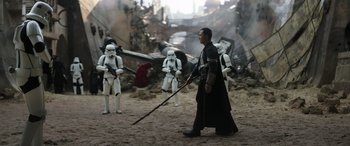 Movie still from “Rogue One: A Star Wars Story” (2016), directed by Gareth Edwards – A group of stormtroopers are standing in the dirt; Wide shot, Over the shoulder angle