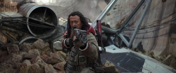 Movie still from “Rogue One: A Star Wars Story” (2016), directed by Gareth Edwards – A man with a gun in his hand and a backpack; Medium shot, Low angle