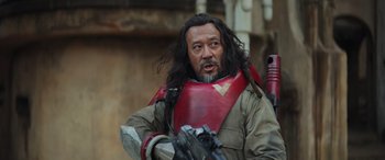 Movie still from “Rogue One: A Star Wars Story” (2016), directed by Gareth Edwards – A man with long black hair and a beard; Close Up shot, Over the shoulder angle