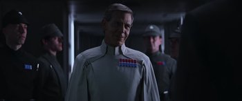 Movie still from “Rogue One: A Star Wars Story” (2016), directed by Gareth Edwards – A man in a uniform standing next to another man in a uniform; Close Up shot, Over the shoulder angle