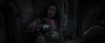 Movie still from “Rogue One: A Star Wars Story” (2016), directed by Gareth Edwards – An asian man with long black hair wearing a helmet; Close Up shot, Over the shoulder angle