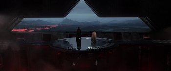 Movie still from “Rogue One: A Star Wars Story” (2016), directed by Gareth Edwards – Two people are sitting on a platform in front of mountains; Extreme Wide shot, Low angle