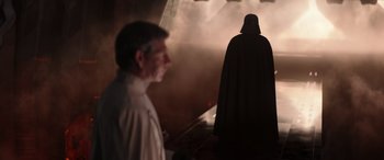 Movie still from “Rogue One: A Star Wars Story” (2016), directed by Gareth Edwards – A man and a darth vader in a dark room; Medium shot, Over the shoulder angle