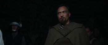 Movie still from “Rogue One: A Star Wars Story” (2016), directed by Gareth Edwards – A man with a beard wearing a brown cape; Close Up shot, Low angle