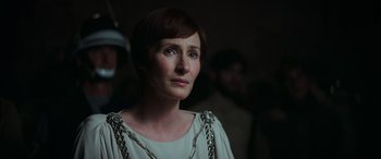 Movie still from “Rogue One: A Star Wars Story” (2016), directed by Gareth Edwards – A person with short hair wearing chains; Close Up shot, Over the shoulder angle