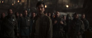 Movie still from “Rogue One: A Star Wars Story” (2016), directed by Gareth Edwards – A man standing in front of a group of people; Medium shot, Over the shoulder angle