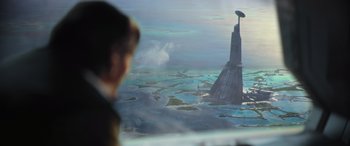 Movie still from “Rogue One: A Star Wars Story” (2016), directed by Gareth Edwards – A man looking out of a window at an island in the ocean; Extreme Wide shot, Low angle