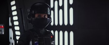 Movie still from “Rogue One: A Star Wars Story” (2016), directed by Gareth Edwards – A person in a black suit and a helmet; Close Up shot, Over the shoulder angle