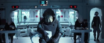 Movie still from “Rogue One: A Star Wars Story” (2016), directed by Gareth Edwards – A person in a spacesuit sitting on a chair; Medium shot, Over the shoulder angle