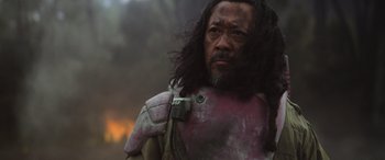 Movie still from “Rogue One: A Star Wars Story” (2016), directed by Gareth Edwards – A man with long black hair wearing a pink and white armor; Close Up shot, Low angle